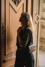 Kép betöltése a galériamegjelenítőbe: Borsetă elegantă din piele neagră cu model modern, purtată crossbody de o femeie