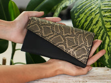 Load image into Gallery viewer, Borsetă elegantă neagră și auriu, deschisă, ținută în mână