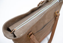 Load image into Gallery viewer, Prim-plan cu o geantă bej cu fermoar auriu pe fundal alb.

