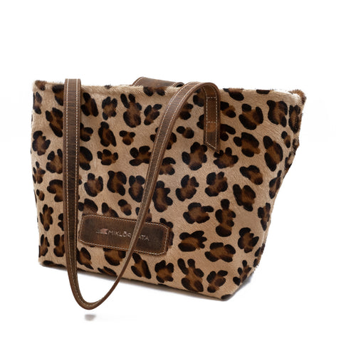 Geantă cu imprimeu leopard și bretea din piele maro, pe fundal alb.
